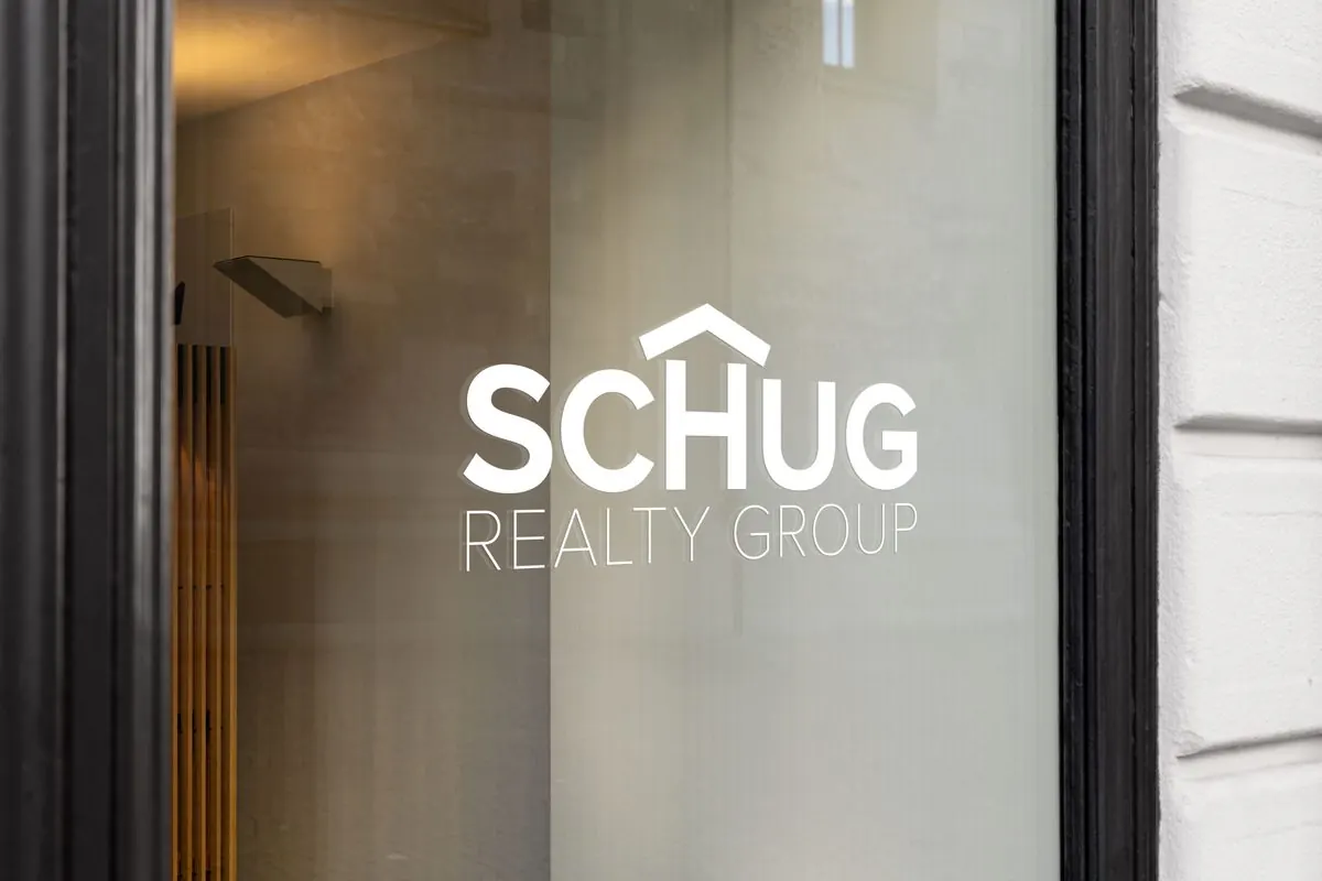 Schug Realty Group logo on glass storefront window